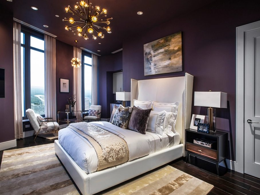 Modern bedroom with a rich aubergine feature wall and layered bedding