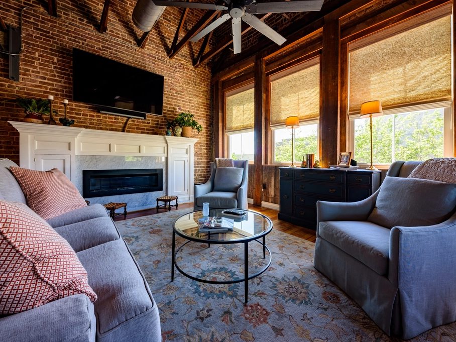 Contemporary living room with an exposed brick wall and exposed timber ceiling