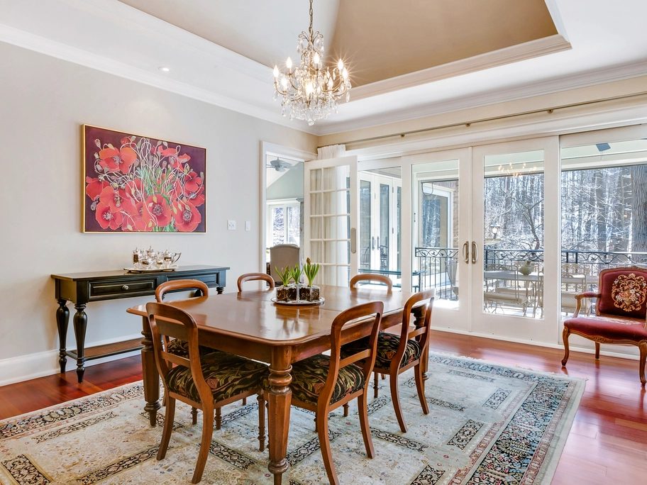 Dining room with a soft neutral palette, framed artwork and a chandelier
