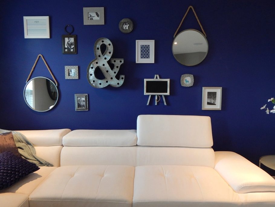 Living room with a deep navy accent wall and a curated arrangement of framed art