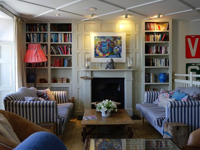 Classic study lined with built-in bookshelves and a painted panelled fireplace wall